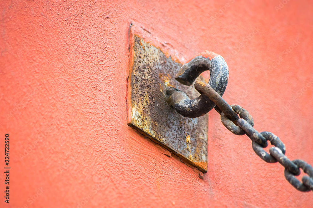 The chain attached to the wall with a metal ring