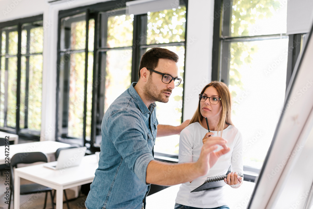 Fototapeta premium Beautiful business woman and man working with flipchart.