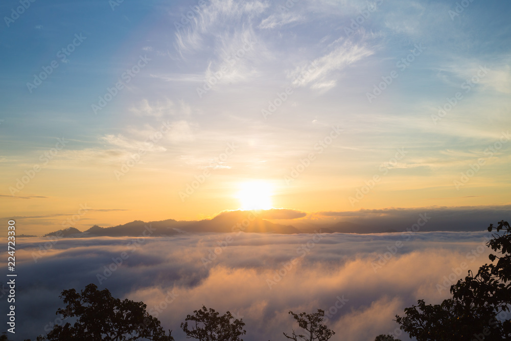 Mountain range with visible silhouettes through the morning colorful fog.