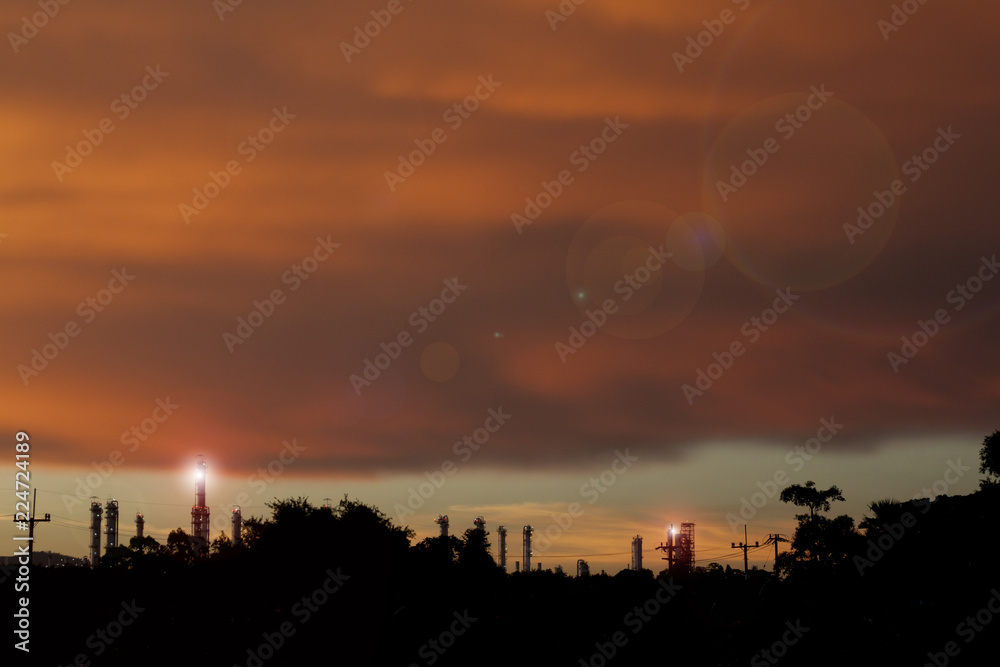 Silhouette of nature with industrial under orange cloud and sky.