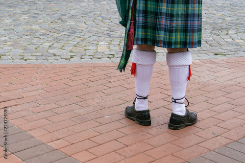 The legs of a man in a tartan skirt