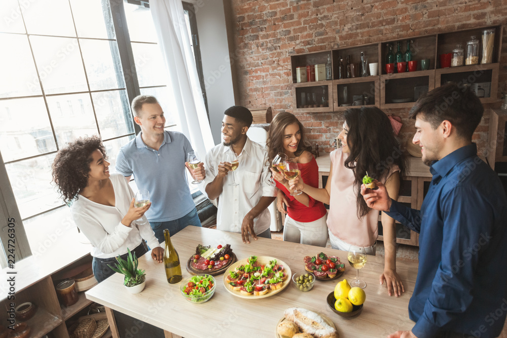Multiracial friends talking and enjoying party at home Multiracial friends talking and enjoying party at home