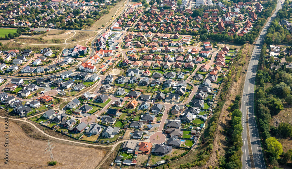 Aerial view of a German suburb with streets and many small houses for families, photographed by a gyrocopter. - obrazy, fototapety, plakaty 