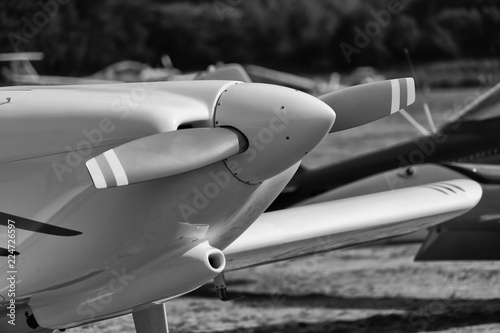 Black and white developed image of the front part of a single engine propeller aircraft.