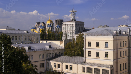 typical urban development in eastern Europe (Ukraine) with an Orthodox church on a background of house dwellings and a blue sky © AndriiShuman
