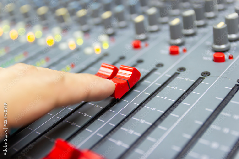 Close-up hand of man control Mixing Console of a big HiFi system The audio equipment, control panel of digital studio mixer.  