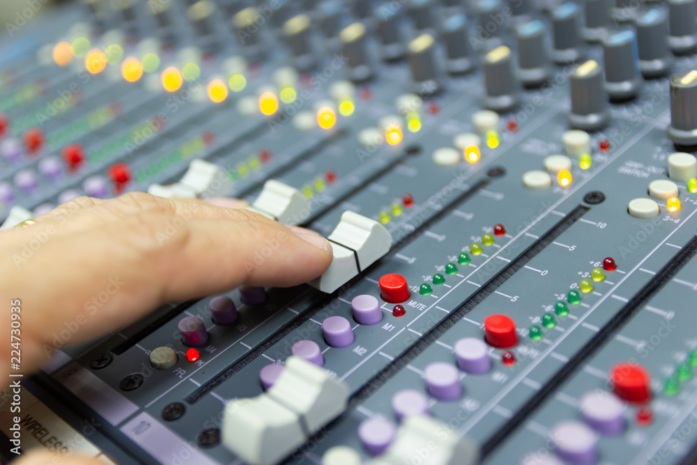 Close-up hand of man control Mixing Console of a big HiFi system The audio equipment, control panel of digital studio mixer.  