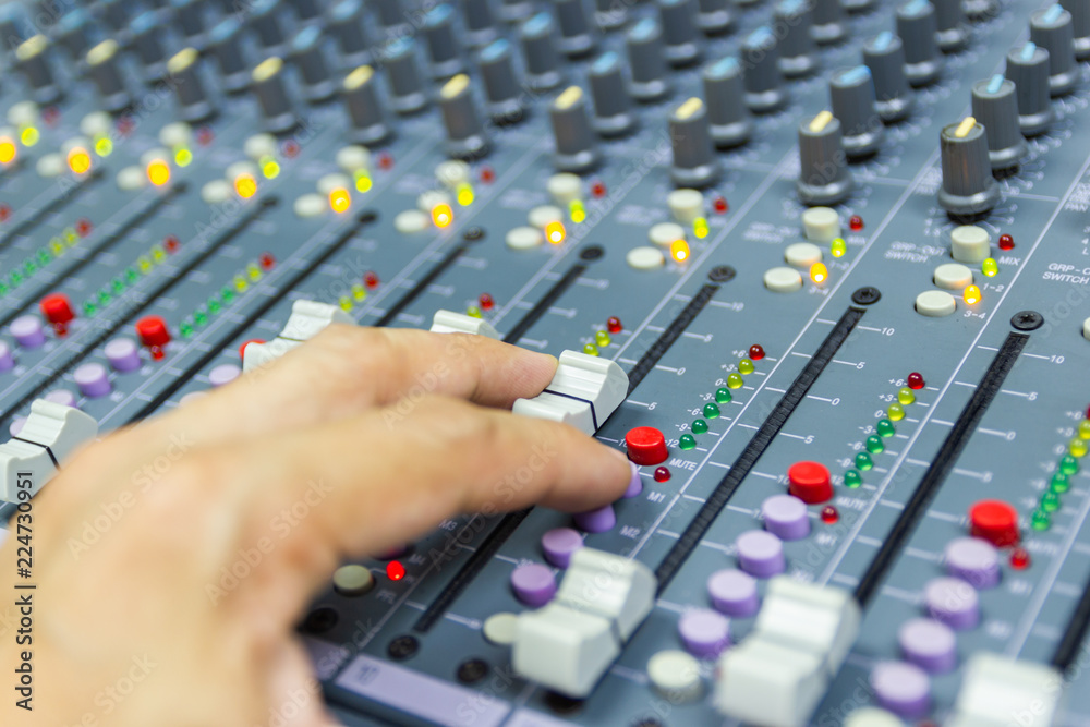 Close-up hand of man control Mixing Console of a big HiFi system The audio equipment, control panel of digital studio mixer. Close-up hand of man control Mixing Console of a big HiFi system The audio equipment, control panel of digital studio mixer.
