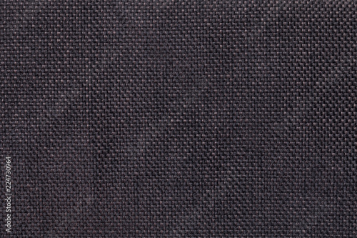 Dark brown background of dense woven bagging fabric, closeup. Structure of the textile macro.