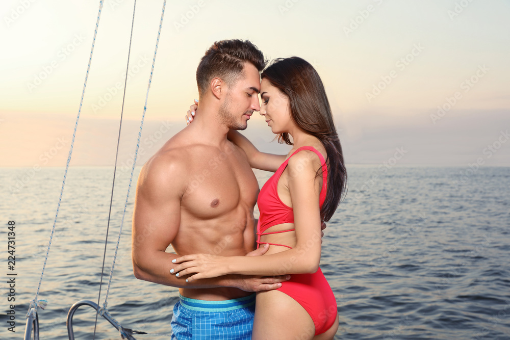 Young man and his beautiful girlfriend in bikini on yacht. Happy couple during sea trip Young man and his beautiful girlfriend in bikini on yacht. Happy couple during sea trip