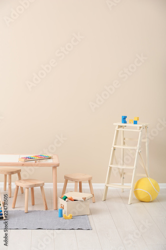 Stylish child's room interior with toys and new furniture, space for text photo