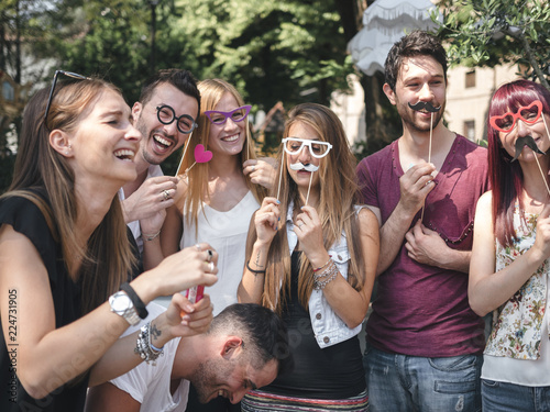 group of friends doing a photo boot with props outdoor