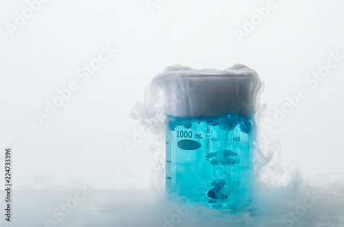 Tableau sur toile Beaker with blue liquid engender white smoke. Dry ice effect