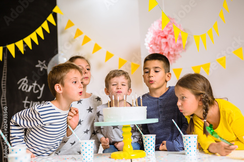Canvas Print Children blowing candles on birthday cake