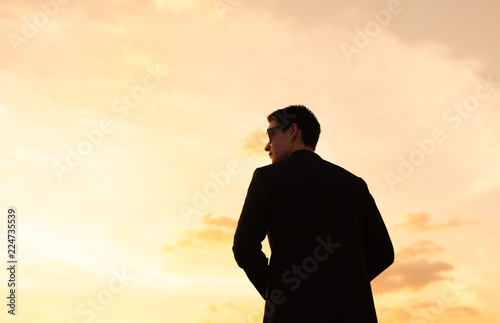Young thoughtful man wearing suit looking toward the horizon. 