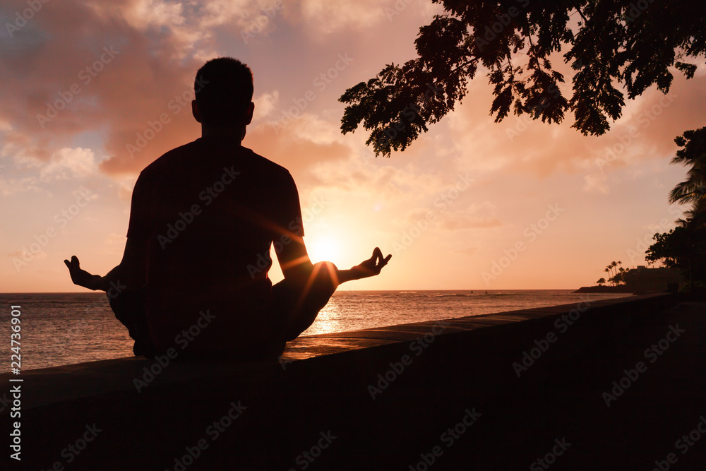 Peaceful meditation and personal reflection. Man meditating at sunset. Peaceful meditation and personal reflection. Man meditating at sunset.