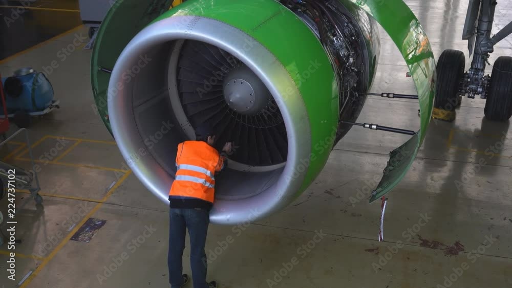 Maintenance of aircraft. Repair of the tail of the aircraft. The engineer repairing the aircraft.. 4k. Maintenance of aircraft. Repair of the tail of the aircraft. The engineer repairing the aircraft.. 4k.
