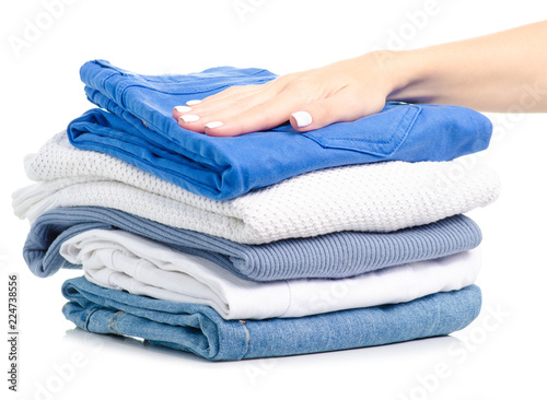Stack of clothing jeans sweaters in hand on a white background isolation