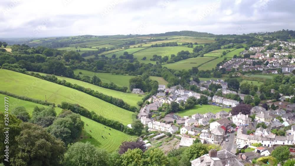 Pan right of the town of Launceston, cornwall, on a sunny summer afternoon, establishing shot