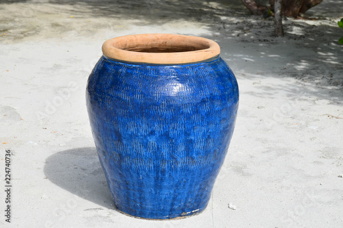Large, blue, hand painted pot on white sand in the Maldives