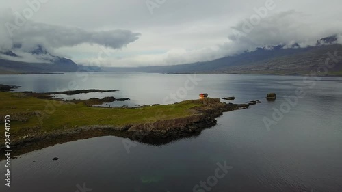 Eastern Icelandic drone shot of small rock pile and lighthouse near coast