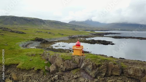 Eastern Icelandic drone shot of small rock pile and lighthouse near coast
