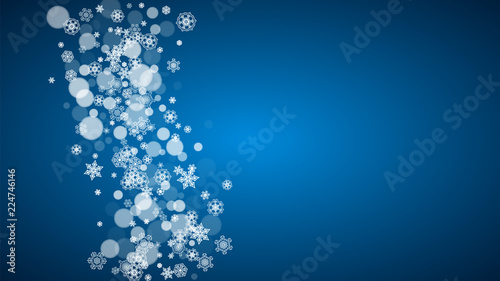Christmas frame with falling snow on blue background. Horizontal Merry Christmas frame with white frosty snowflakes for banners, gift cards, party invitations and special business offers.