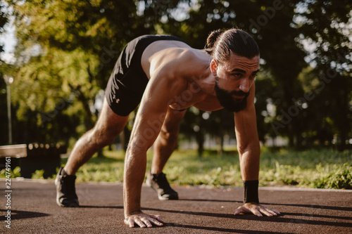 Man doing dive bomber push ups in the outdoor gym