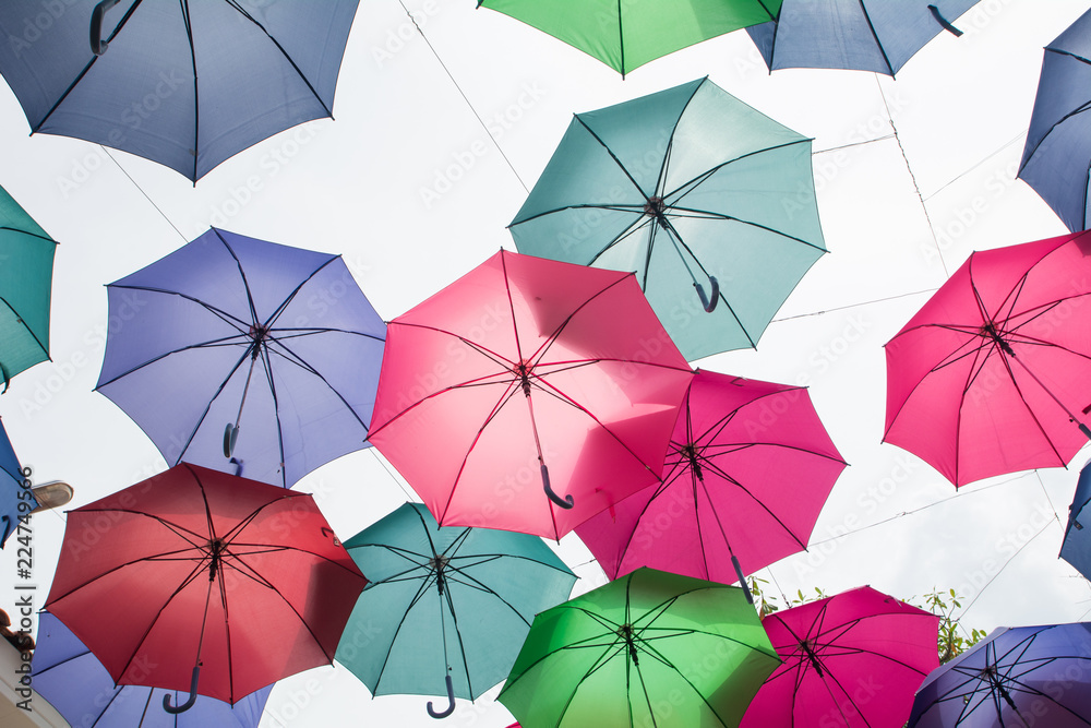 Beautiful display of colorful hanging umbrellas in a outdoor, Colorful hanging umbrellas on white sky background in Sunny day