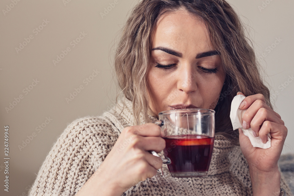 Flu cold or allergy symptom. Sick young woman with fever sneezing in tissue, allergies, the common cold laying on the bed. Flu cold or allergy symptom. Sick young woman with fever sneezing in tissue, allergies, the common cold laying on the bed.
