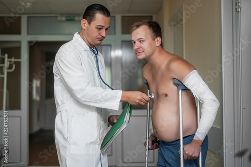 doctor listens to the client using a stethoscope in the hospital