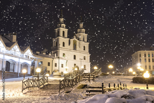 Snowfall in Minsk at winter night, Belarus. New Year and Christmas time in Minsk city. Cityscape of snowy Minsk. Cathedral of the Holy Spirit.