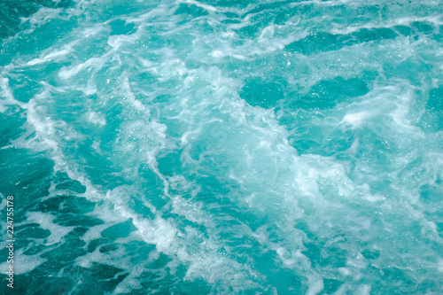 Troubled aqua blue sea water with white foam, abstract nature background concept