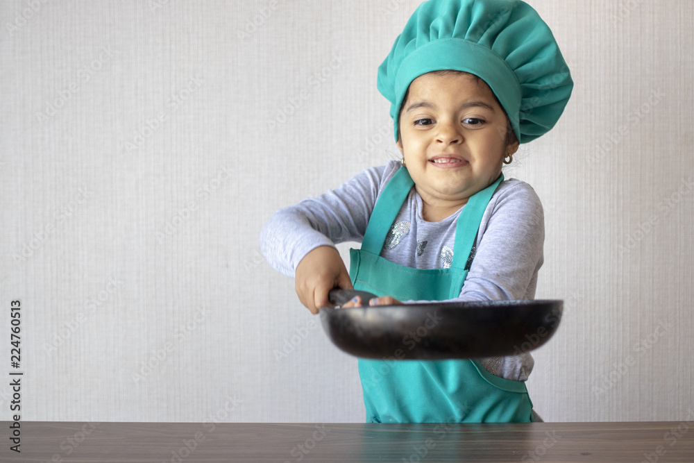 Cute little girl cooking with her frying pan Cute little girl cooking with her frying pan
