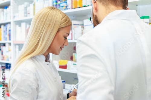 Colleagues pharmacists and chemists working at pharmacy drugstore