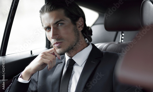 successful man sitting in the back seat of a car © ASDF