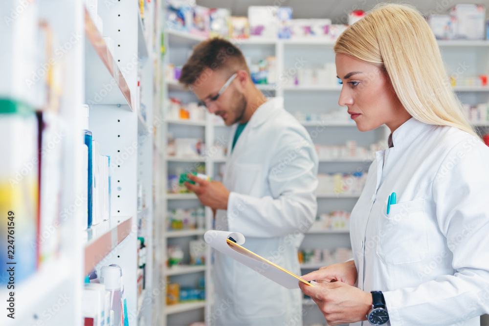 Colleagues pharmacists and chemists working at pharmacy drugstore