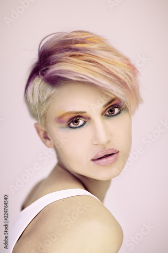 Fashion beautiful blonde woman with short haircut and colorful pastel hair and make up