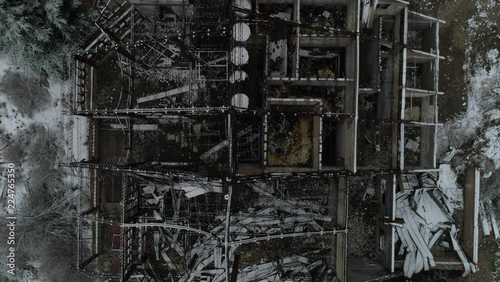 Aerial senital drone scene of destroyed building, old burned hotel in snowy day. General view of metal structure of construction and top view of rooms distribution. Camera moves along lost hotel Aerial senital drone scene of destroyed building, old burned hotel in snowy day. General view of metal structure of construction and top view of rooms distribution. Camera moves along lost hotel