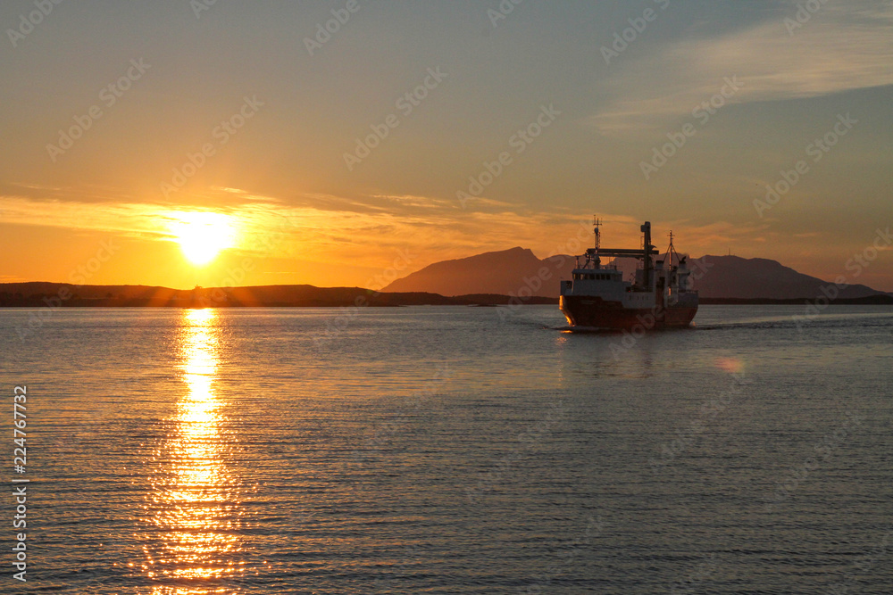 Ship in sunset arrives Bronnoysund harbor in Northern Norway