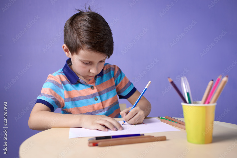 Caucasian boy carefully drawing with colorful pencils. Caucasian boy carefully drawing with colorful pencils.