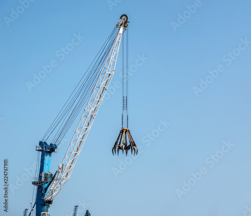 Big construction crane on blue sky background copy space