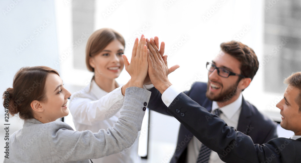 successful business team giving each other a high-five, standing in the office successful business team giving each other a high-five, standing in the office
