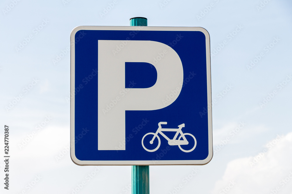 Blue bycicle parking vertical sign on blue sky Blue bycicle parking vertical sign on blue sky