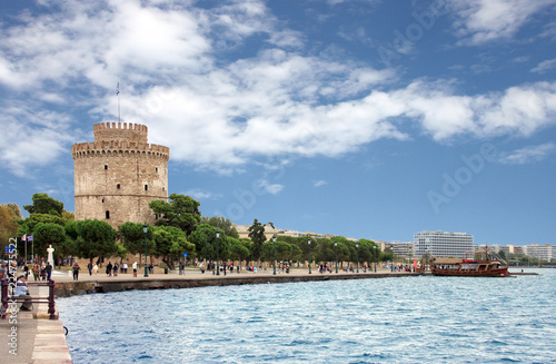 White tower of thessaloniki with a touristic boat on the right photo