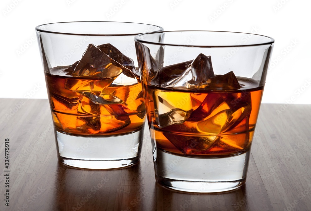 Glasses of Whiskey and Ice on Wooden Table Glasses of Whiskey and Ice on Wooden Table