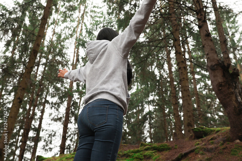 Woman on walk in beautiful coniferous forest