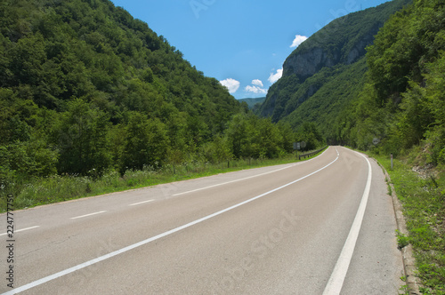 An empty road going through Vrbas valley in the midday sun