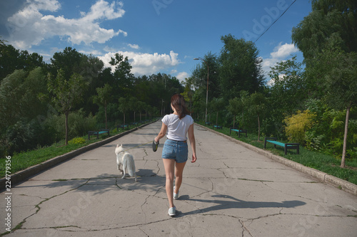 Back view woman walking her dog in the park photo