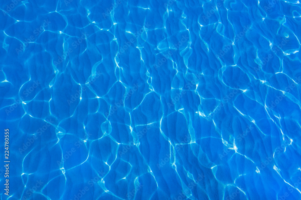 Blue and bright ripple water, surface water in swimming pool or sea. Beautiful motion gentle waves.